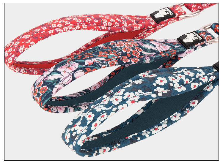 Slitstarkt hundkoppel i rött med blommig design och flera greppunkter.